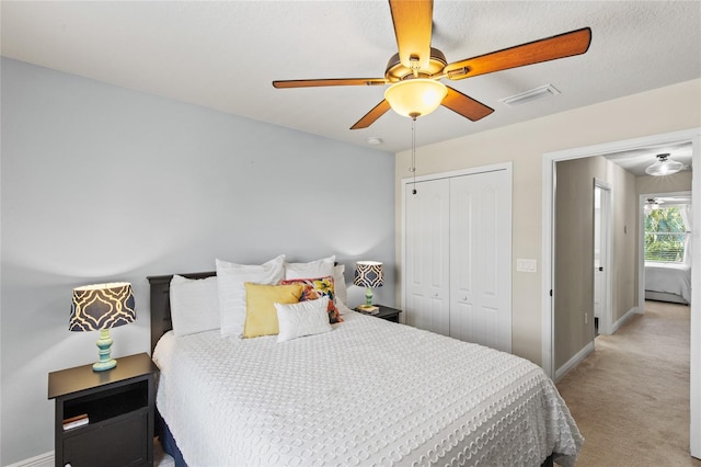 carpeted bedroom featuring a closet and ceiling fan