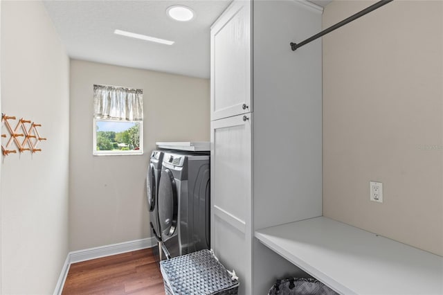 laundry room with washer and dryer, hardwood / wood-style floors, and cabinets