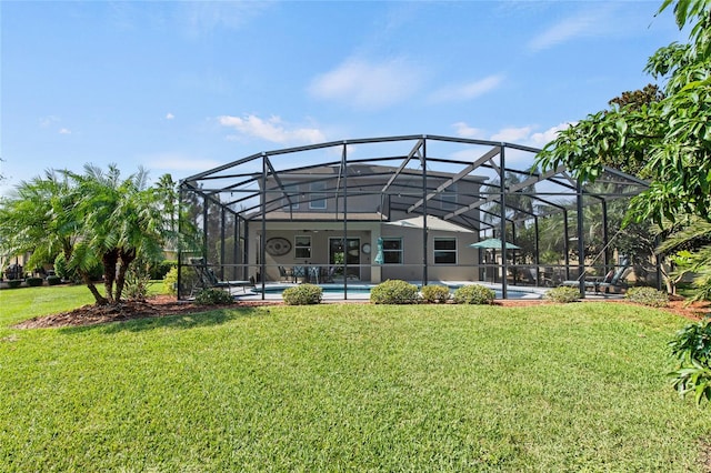 rear view of house featuring a lanai and a yard