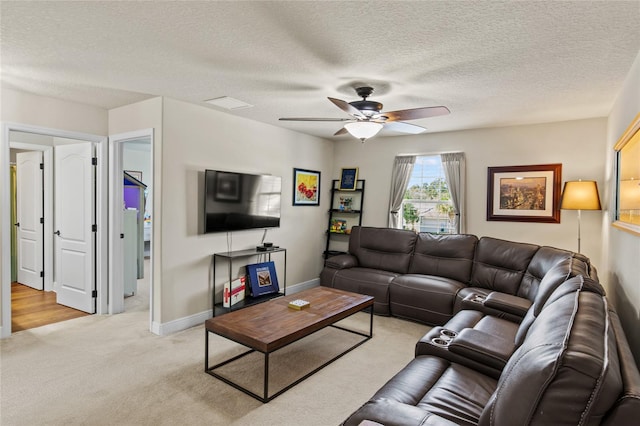 carpeted living room with ceiling fan and a textured ceiling