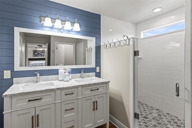 bathroom with vanity, a textured ceiling, and a shower with shower door