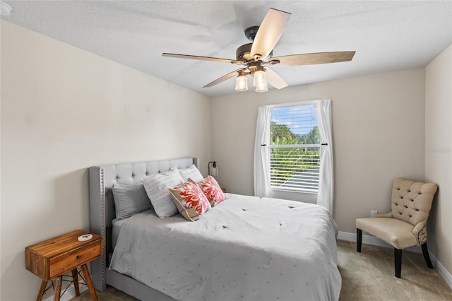 bedroom with a textured ceiling, ceiling fan, and light colored carpet