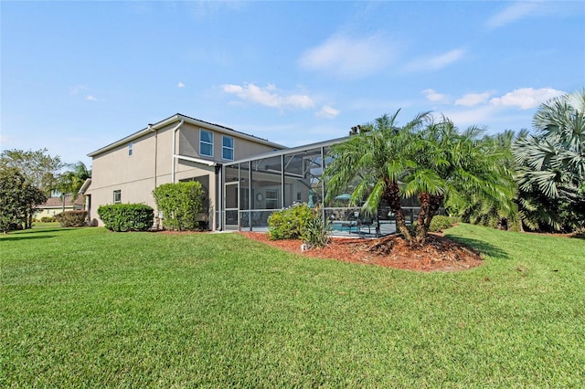 back of property with a lanai and a lawn