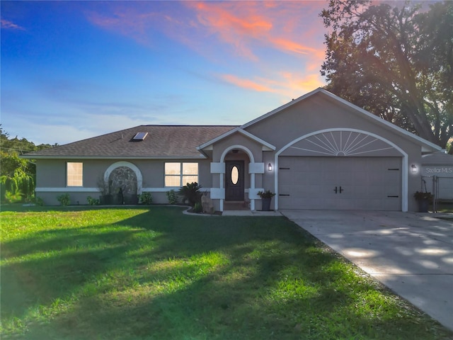 ranch-style home featuring a yard and a garage