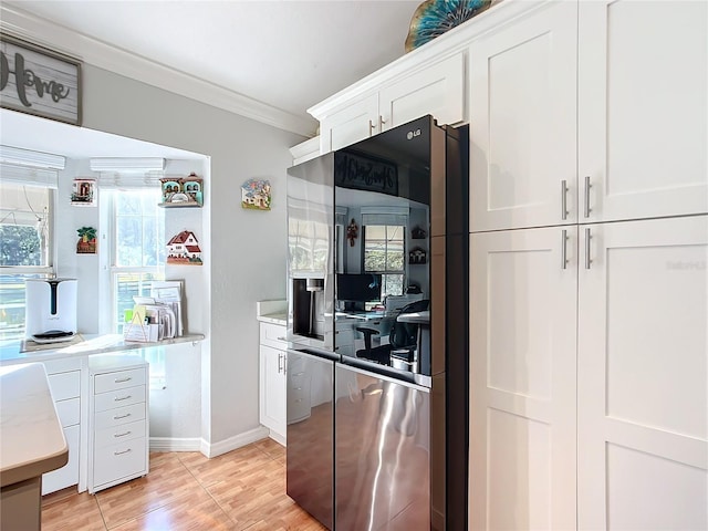 kitchen with light hardwood / wood-style floors, white cabinets, crown molding, and stainless steel refrigerator