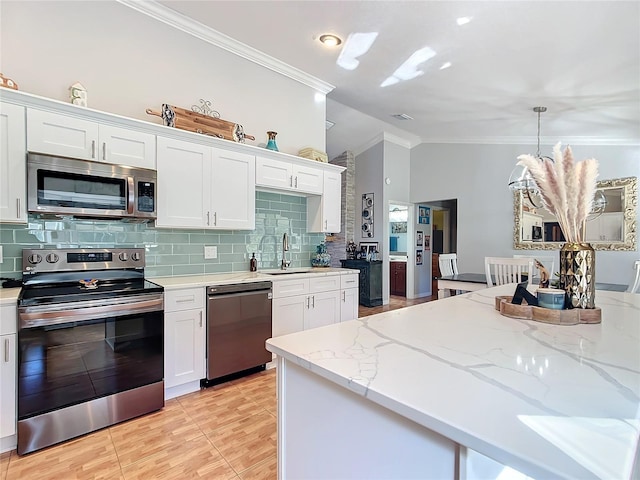 kitchen with white cabinetry, pendant lighting, and stainless steel appliances