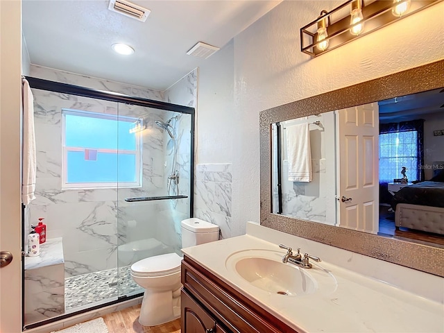 bathroom with toilet, a shower with door, hardwood / wood-style floors, and vanity