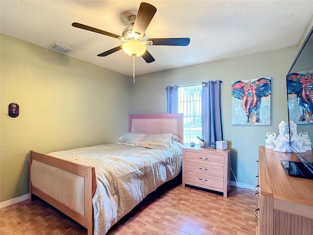 bedroom featuring ceiling fan and a textured ceiling