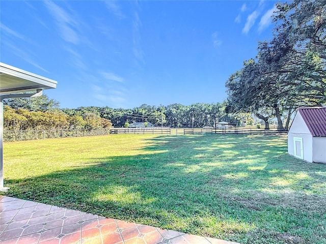 view of yard featuring a rural view and a storage unit