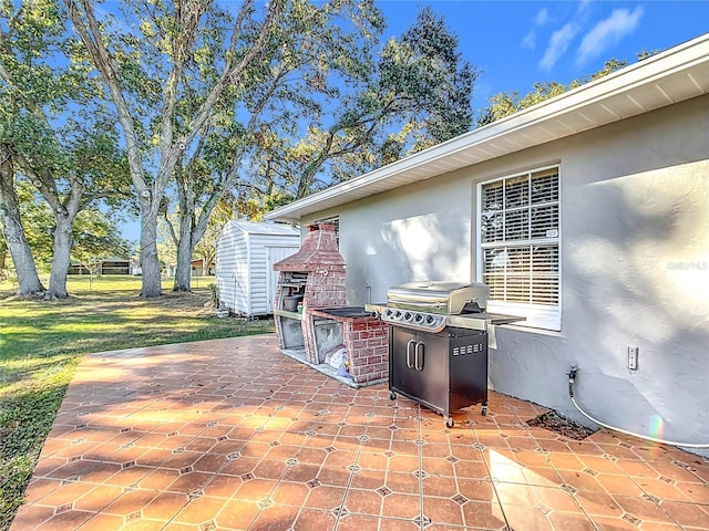 view of patio / terrace featuring an outdoor fireplace and a storage shed