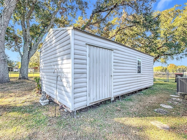 view of outbuilding featuring central AC unit and a yard