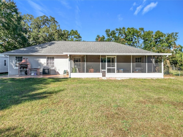 back of house with a lawn and a sunroom