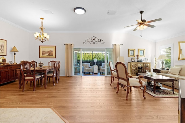 dining space with ceiling fan with notable chandelier, light wood-type flooring, vaulted ceiling, and crown molding