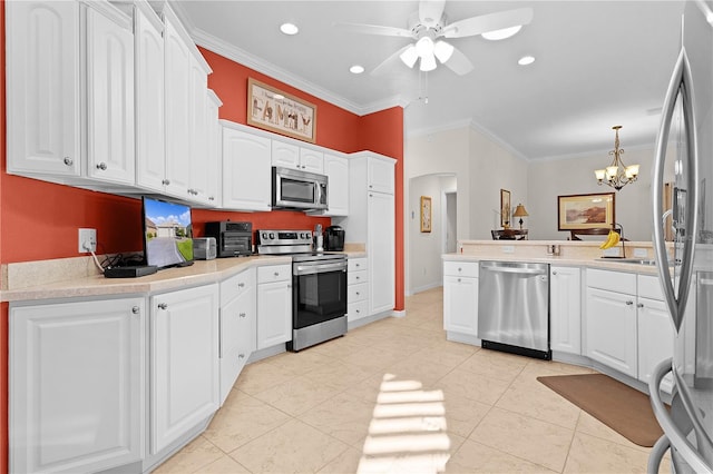 kitchen featuring stainless steel appliances, decorative light fixtures, white cabinets, ceiling fan with notable chandelier, and ornamental molding