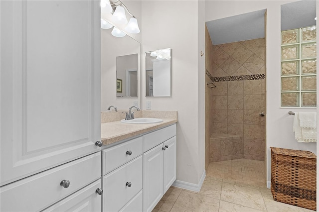 bathroom featuring tiled shower and vanity