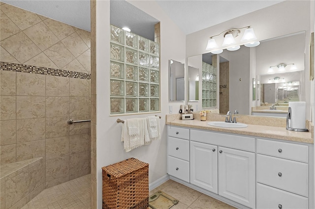 bathroom with tile patterned flooring, a textured ceiling, vanity, and tiled shower