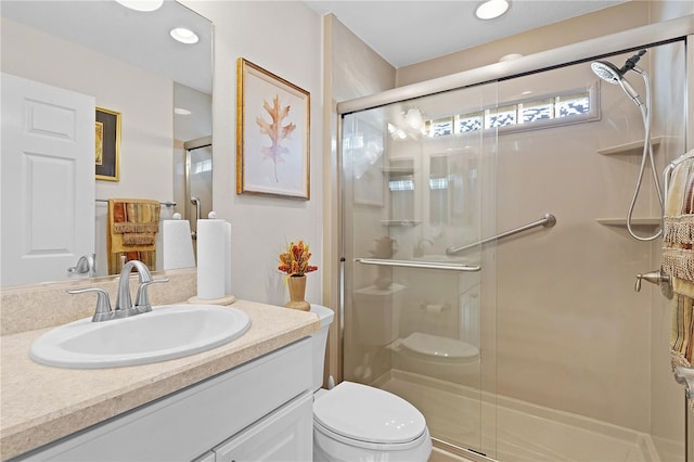 bathroom featuring vanity, toilet, and a shower with door