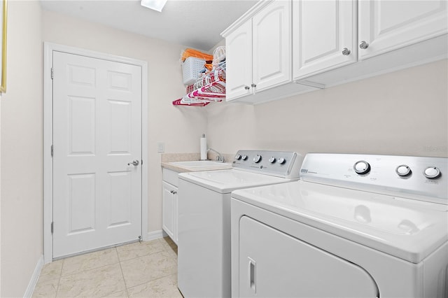 clothes washing area with cabinets, light tile patterned floors, washer and clothes dryer, and sink