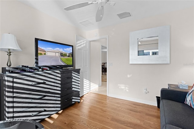 living room featuring hardwood / wood-style floors and ceiling fan