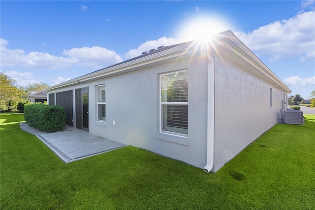 back of house featuring a lawn, central air condition unit, and a patio