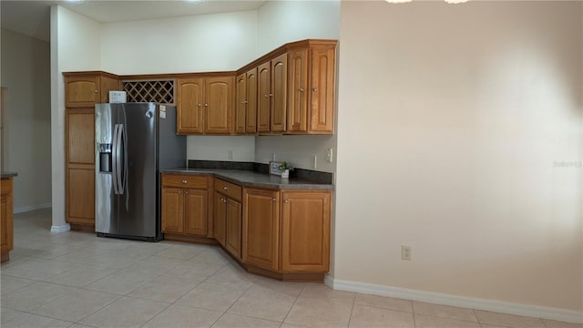 kitchen with stainless steel fridge and light tile patterned floors