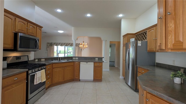 kitchen with stainless steel appliances, sink, pendant lighting, a notable chandelier, and light tile patterned flooring