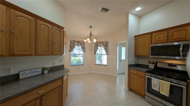 kitchen with hanging light fixtures, a notable chandelier, a textured ceiling, light tile patterned flooring, and appliances with stainless steel finishes