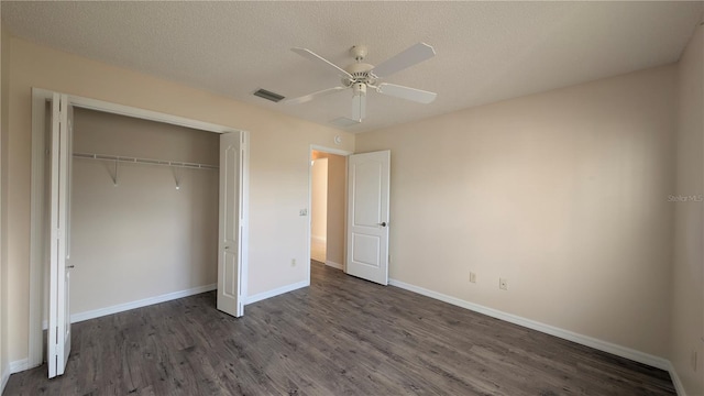 unfurnished bedroom featuring a textured ceiling, ceiling fan, a closet, and dark hardwood / wood-style floors