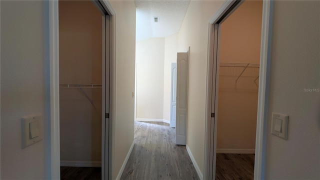 hallway with wood-type flooring and a textured ceiling