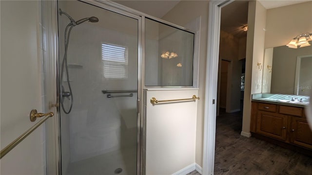 bathroom featuring hardwood / wood-style floors, vanity, and a shower with shower door