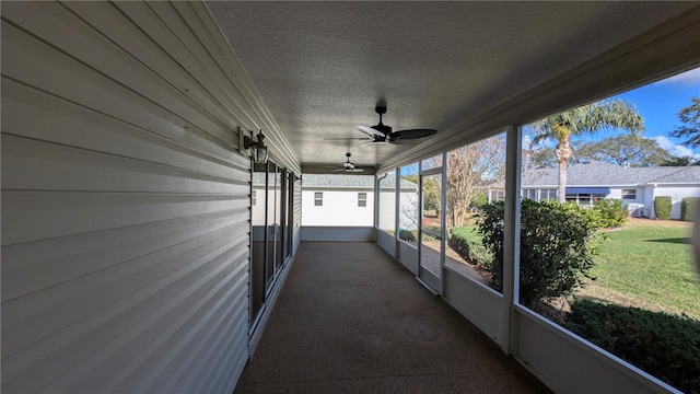 unfurnished sunroom with ceiling fan