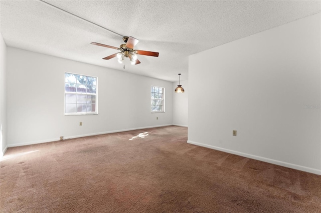 carpeted spare room featuring a textured ceiling and ceiling fan