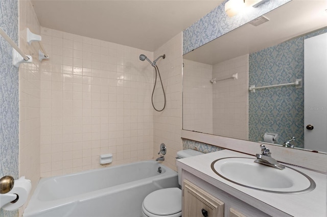 full bathroom with vanity, tiled shower / bath combo, and toilet