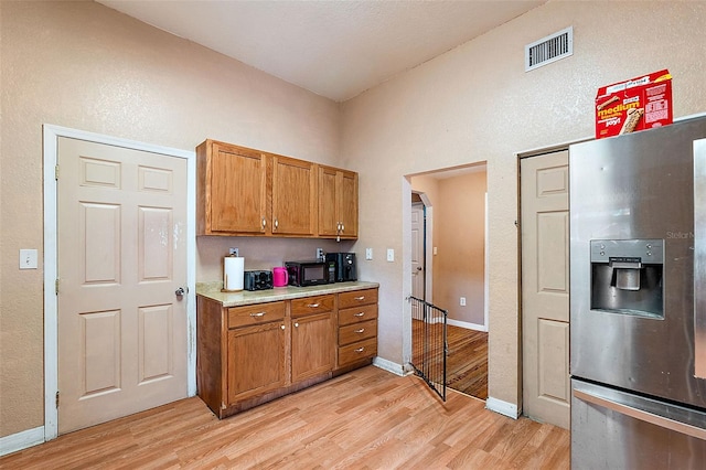 kitchen featuring light hardwood / wood-style floors and stainless steel fridge with ice dispenser