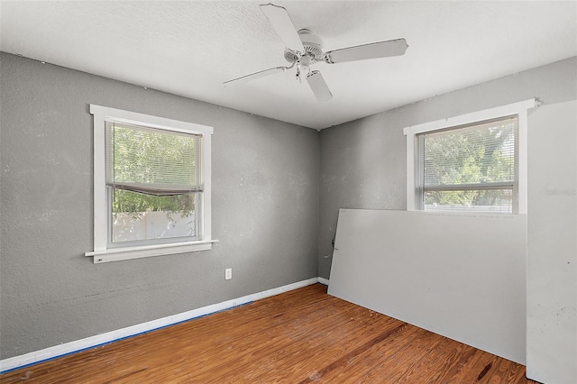 empty room with hardwood / wood-style floors and ceiling fan