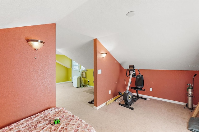 exercise area featuring lofted ceiling and light colored carpet