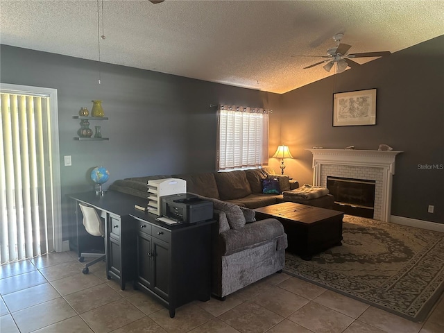 living room featuring lofted ceiling, ceiling fan, a fireplace, tile patterned flooring, and a textured ceiling