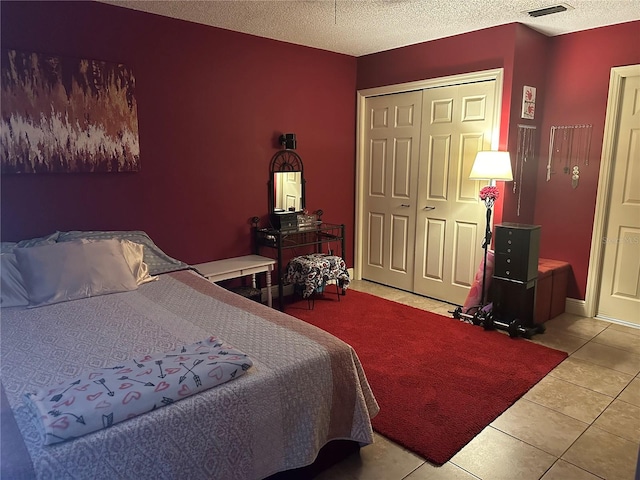 tiled bedroom featuring a closet and a textured ceiling