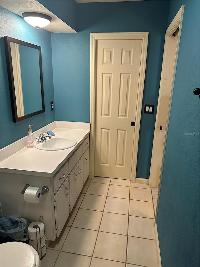 bathroom with tile patterned flooring, vanity, and toilet