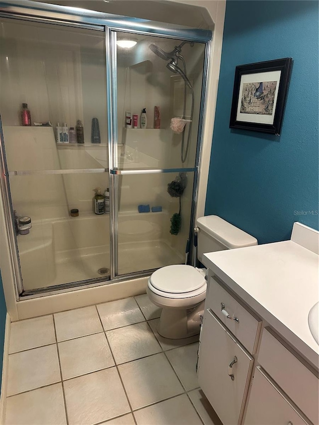 bathroom featuring an enclosed shower, tile patterned floors, vanity, and toilet