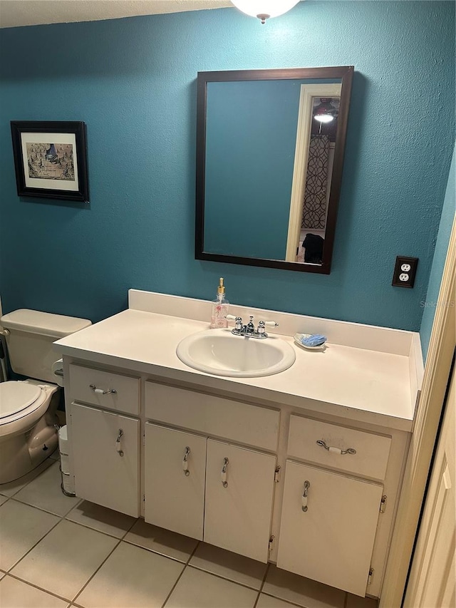 bathroom with vanity, tile patterned flooring, and toilet