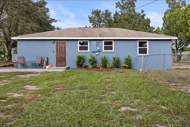 back of house with a lawn and a patio area