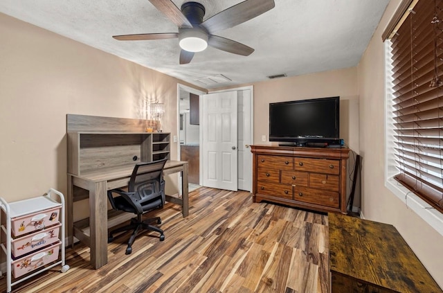 office area with ceiling fan, wood-type flooring, and a textured ceiling