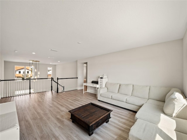 living room featuring a notable chandelier and light wood-type flooring