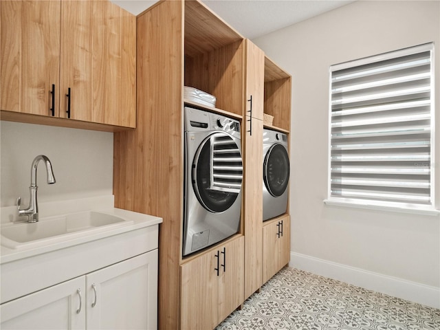 washroom featuring cabinets, sink, separate washer and dryer, and light tile patterned floors