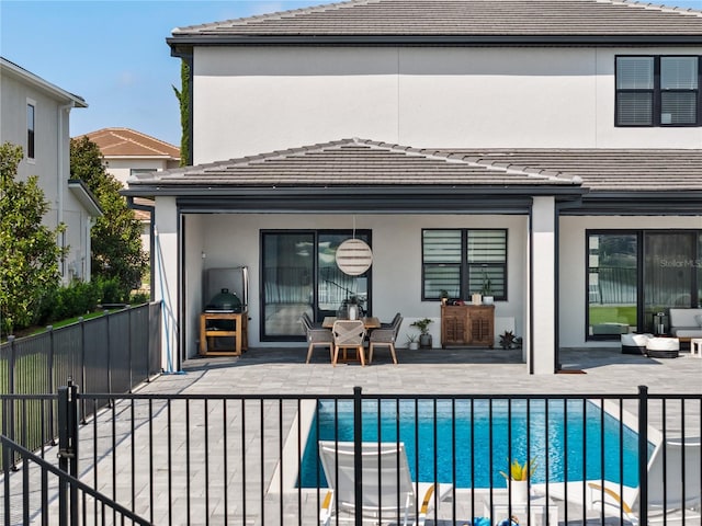 rear view of house with a patio area and a fenced in pool