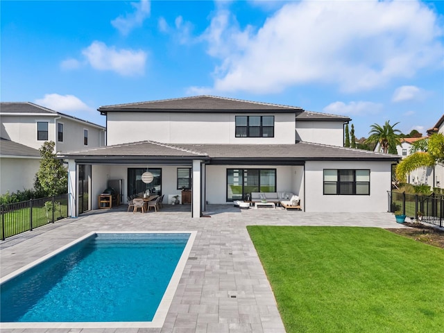 rear view of property with a yard, a patio area, a fenced in pool, and outdoor lounge area