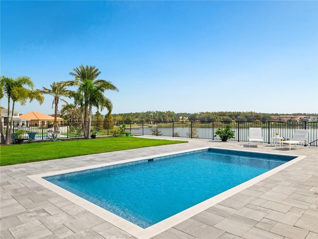 view of pool featuring a patio, a lawn, and a water view