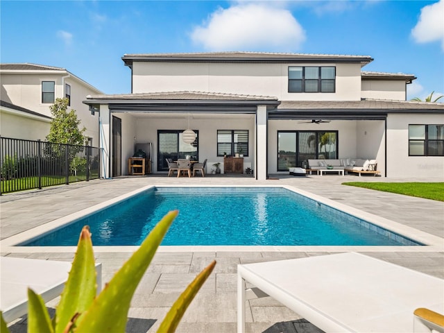 back of house with an outdoor hangout area, a patio, a fenced in pool, and ceiling fan