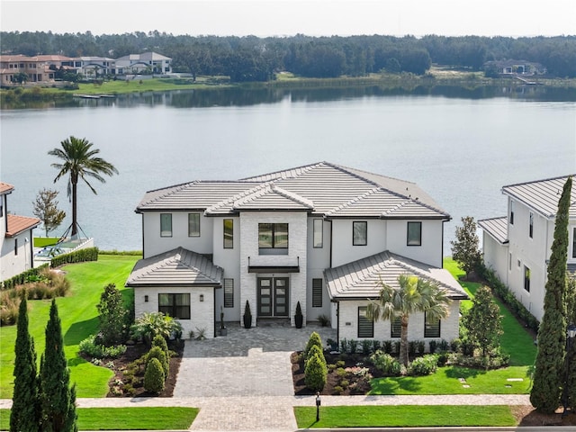 modern inspired farmhouse featuring a front lawn and a water view